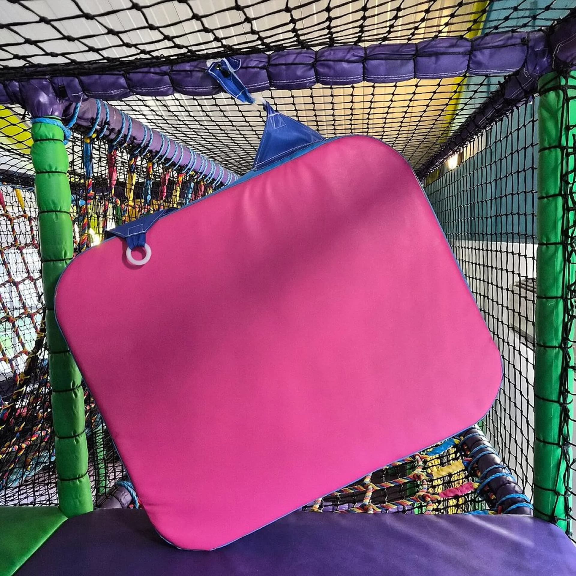 Worn soft play padding and netting inside an indoor play frame needing inspection and maintenance